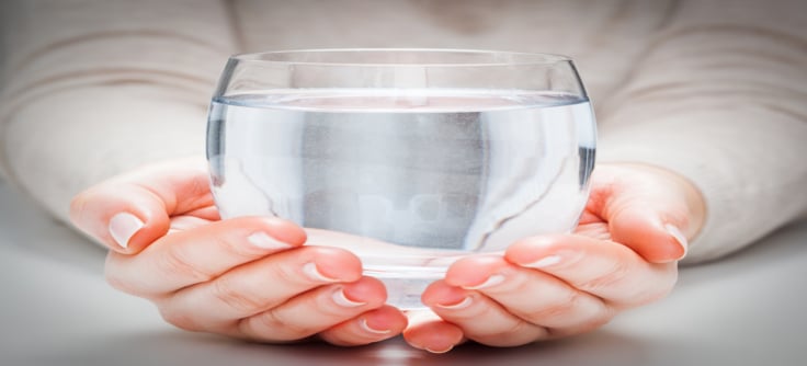 woman holding large glass of water
