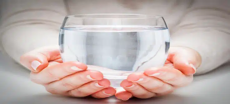 woman holding large glass of water